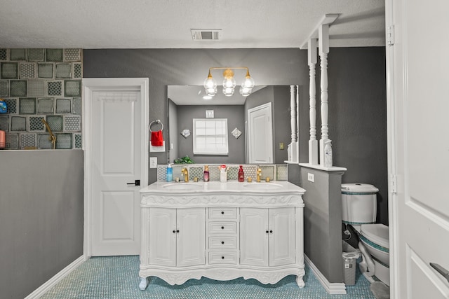 bathroom with vanity, a textured ceiling, and toilet