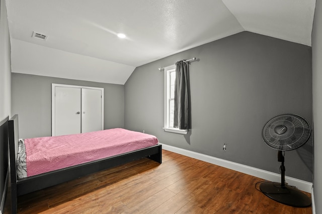 bedroom with vaulted ceiling and wood-type flooring