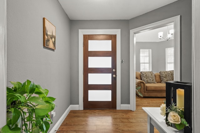 entryway with a notable chandelier and wood-type flooring