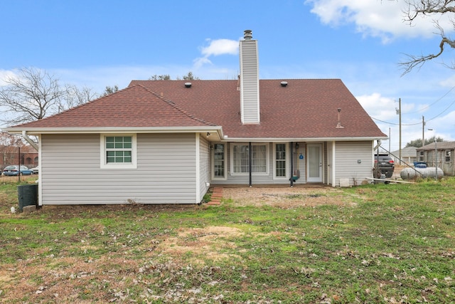 rear view of house featuring a lawn