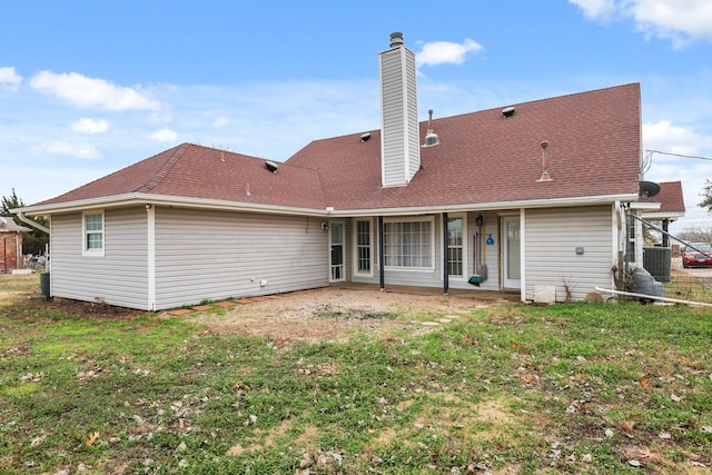 back of house featuring central AC unit and a lawn