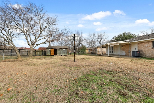 view of yard with central AC, a patio, and a shed