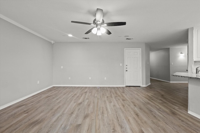 unfurnished room with sink, ceiling fan, and light hardwood / wood-style flooring