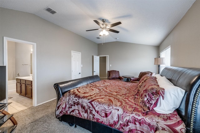 carpeted bedroom featuring ceiling fan, connected bathroom, vaulted ceiling, and a textured ceiling