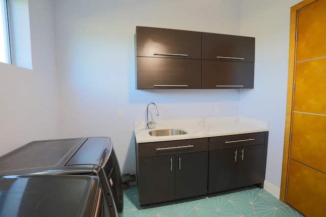 clothes washing area with cabinets, separate washer and dryer, and sink