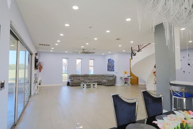 living room with plenty of natural light, light hardwood / wood-style floors, and ceiling fan