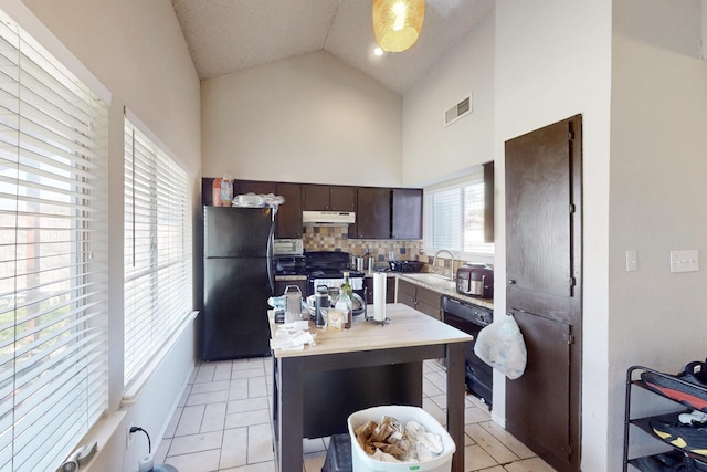 kitchen with sink, dark brown cabinets, tasteful backsplash, black appliances, and vaulted ceiling