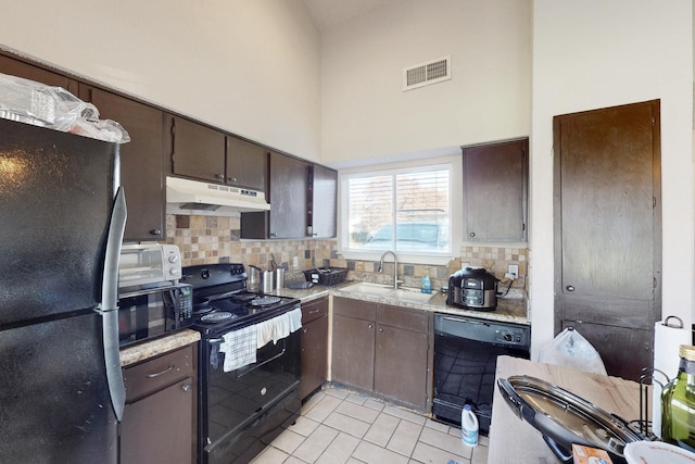 kitchen featuring light tile patterned flooring, sink, dark brown cabinets, and black appliances