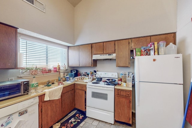 kitchen with a high ceiling and white appliances