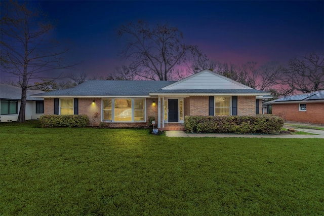 ranch-style house with brick siding and a front lawn