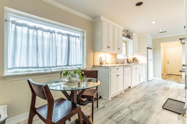 kitchen featuring white appliances, white cabinetry, backsplash, and ornamental molding