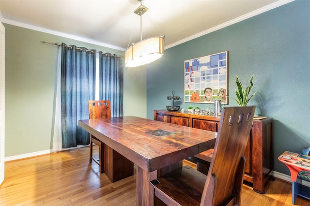 dining area with baseboards, wood finished floors, and crown molding