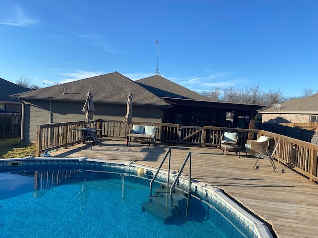 view of swimming pool with a wooden deck, a fenced in pool, and fence