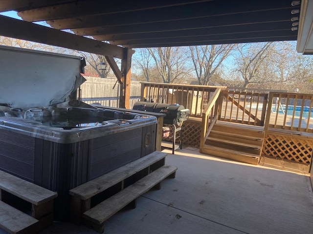 view of patio / terrace with a swimming pool, fence, a wooden deck, and a hot tub