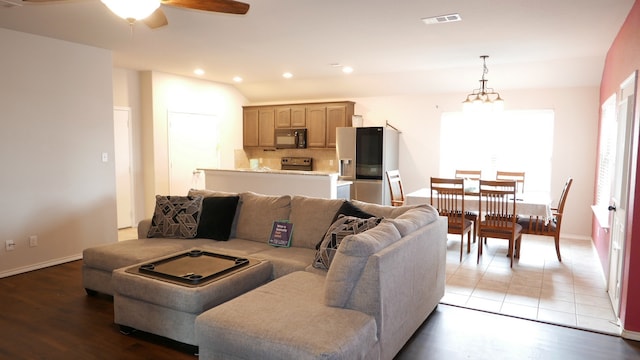 living area featuring light wood-style flooring, ceiling fan with notable chandelier, visible vents, and recessed lighting