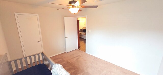 unfurnished room with baseboards, a ceiling fan, and light colored carpet