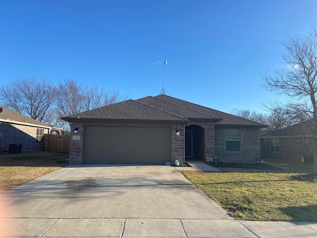 ranch-style home with brick siding, an attached garage, a front yard, fence, and driveway