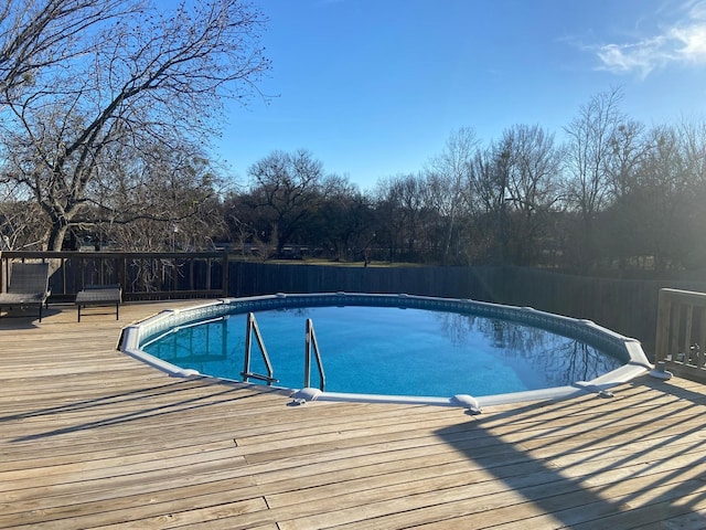 view of pool with a fenced in pool and a deck