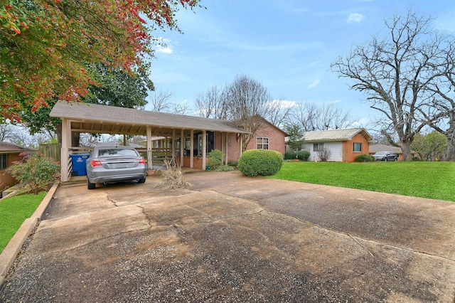 ranch-style house featuring brick siding, driveway, a carport, and a front lawn