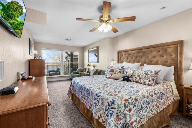 bedroom featuring ceiling fan and dark carpet