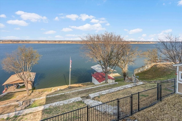 view of water feature with a dock and fence