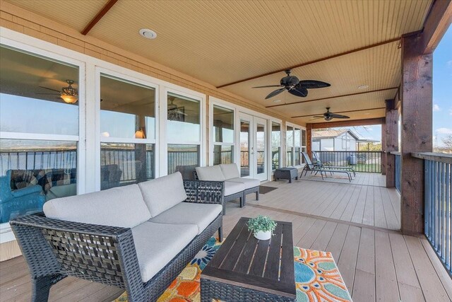 deck with an outdoor living space, ceiling fan, and french doors