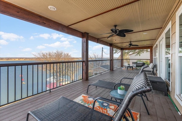 wooden deck with a ceiling fan and a water view