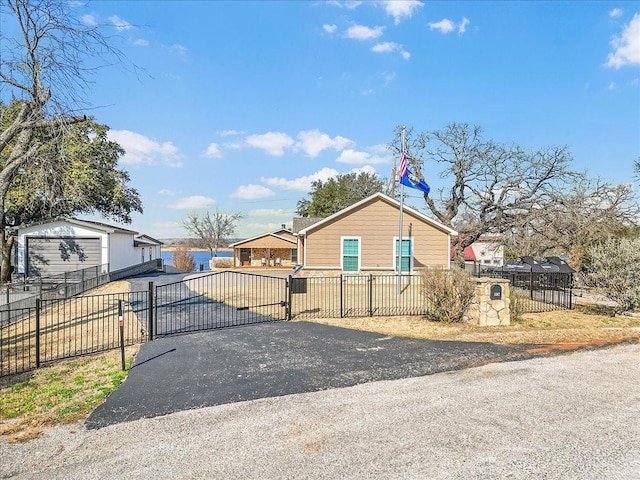 view of front of house featuring driveway, a garage, a gate, and fence