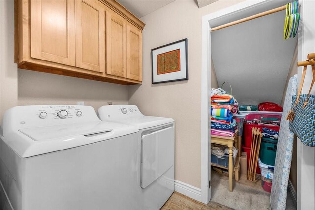 laundry area with separate washer and dryer and cabinets