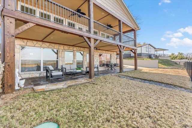 view of yard with ceiling fan, an outdoor hangout area, a patio, and a balcony