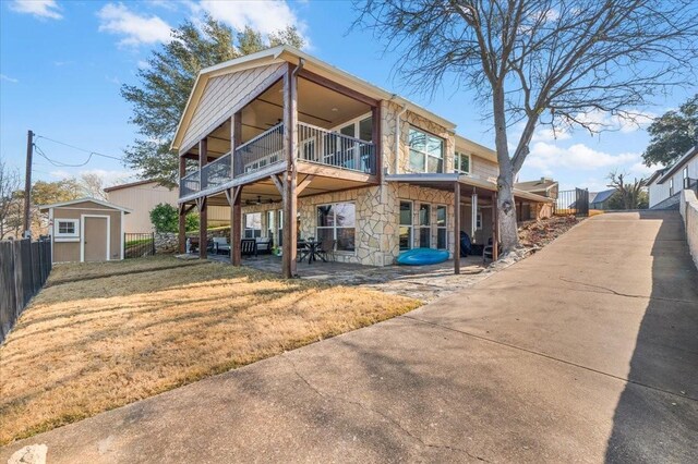 back of property featuring a patio area, a shed, and a lawn