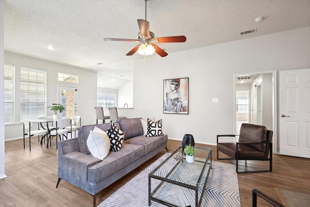 living room with a healthy amount of sunlight, hardwood / wood-style floors, and a textured ceiling