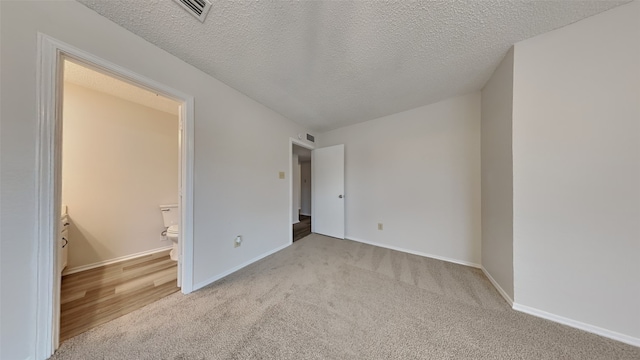 carpeted empty room featuring a textured ceiling