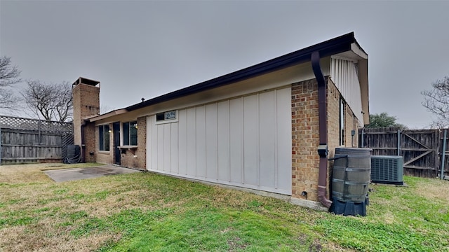 view of property exterior with a patio, a yard, and central air condition unit