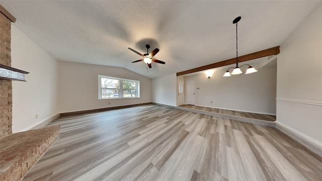 unfurnished living room with ceiling fan with notable chandelier, vaulted ceiling, light hardwood / wood-style floors, and a textured ceiling