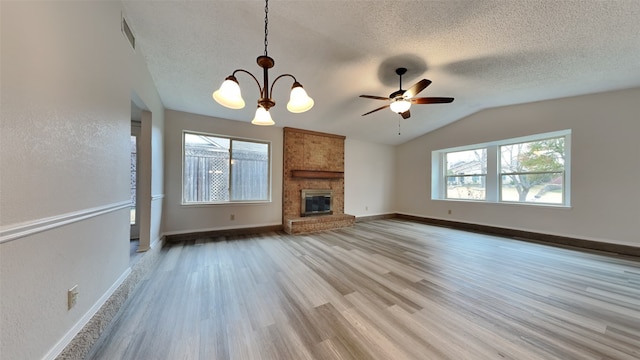 unfurnished living room featuring a wealth of natural light, a fireplace, and a textured ceiling