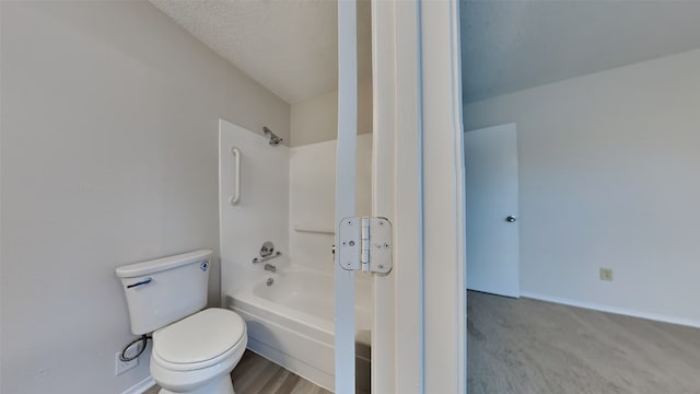 bathroom with shower / tub combination, a textured ceiling, and toilet