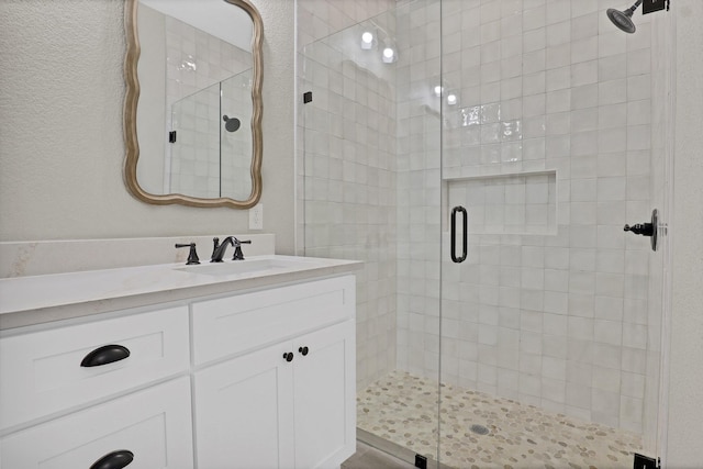 bathroom featuring a shower stall and vanity