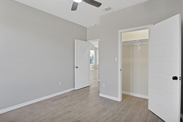 unfurnished bedroom featuring ceiling fan, a closet, and light hardwood / wood-style flooring