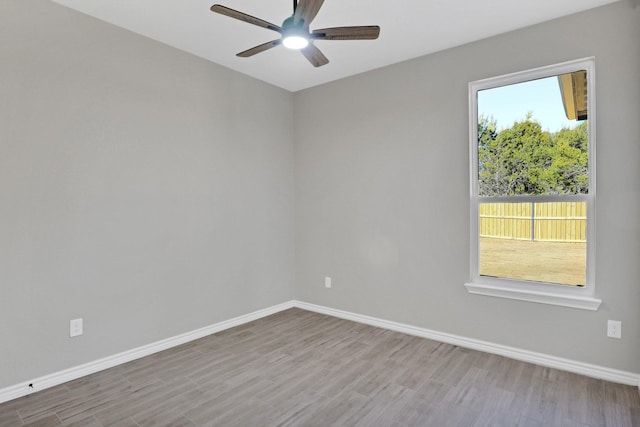 empty room featuring a ceiling fan, baseboards, and wood finished floors