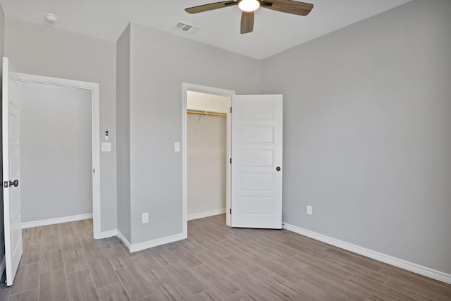 unfurnished bedroom featuring ceiling fan, a closet, and light hardwood / wood-style flooring