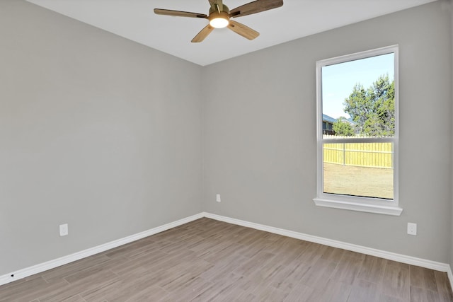 unfurnished room with a ceiling fan, wood finished floors, and baseboards