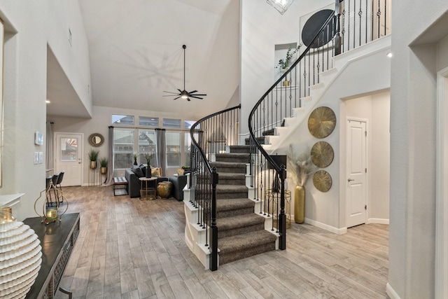 entrance foyer with ceiling fan, high vaulted ceiling, and light hardwood / wood-style flooring