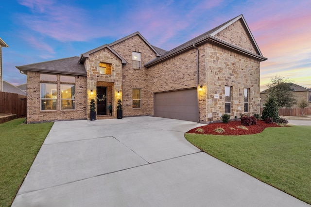 view of front of property featuring driveway, brick siding, a front lawn, and fence