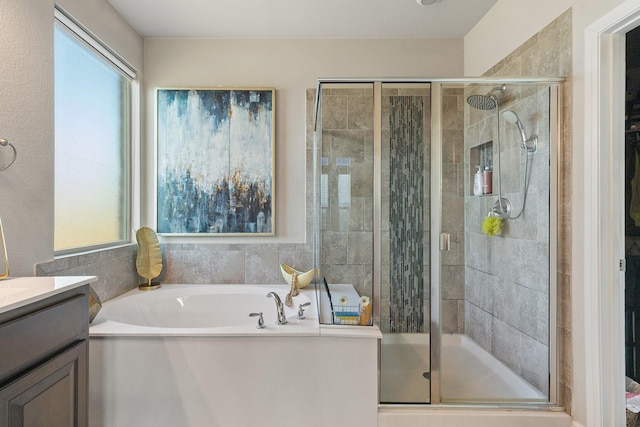 bathroom featuring vanity, a healthy amount of sunlight, and separate shower and tub