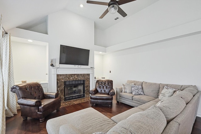 living room featuring dark wood-type flooring, ceiling fan, a fireplace, and high vaulted ceiling