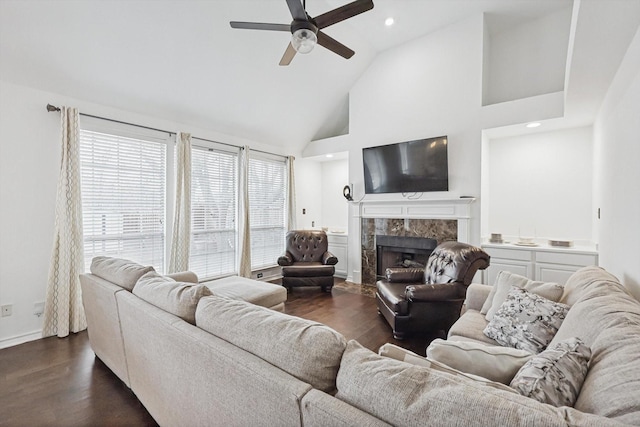 living room featuring dark hardwood / wood-style flooring, a high end fireplace, high vaulted ceiling, and ceiling fan