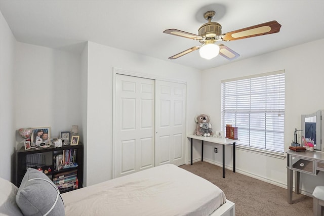 carpeted bedroom featuring ceiling fan and a closet