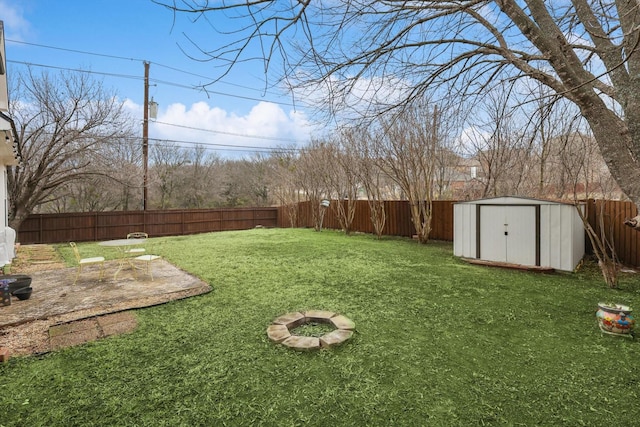 view of yard with a storage shed and a fire pit