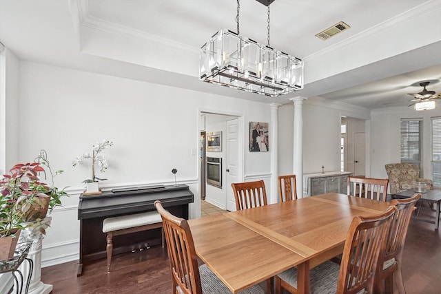 dining space featuring ornate columns, crown molding, wood-type flooring, a tray ceiling, and ceiling fan